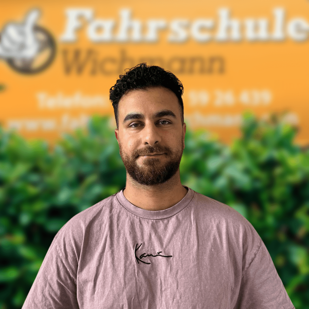 Azidin, Fahrlehrer der Fahrschule Wichmann in Oyten, begleitet dich kompetent auf dem Weg zum Auto-, Motorrad-, LKW- oder Anhängerführerschein sowie bei der Fahrlehrerausbildung – auch in Bassen und Borstel sowie in der Intensivfahrschule. - Wichmann Fahrschule Oyten - Autoführerschein LKW Führerschein Motorradführerschein Azidin, Fahrlehrer der Fahrschule Wichmann in Oyten, vor dem Logo mit grüner Hecke im Hintergrund.