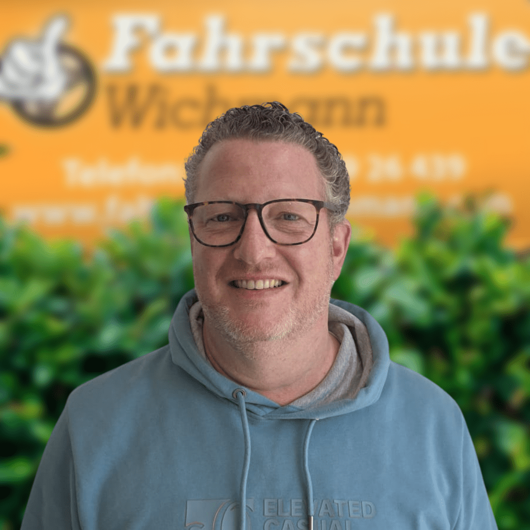 Fahrlehrer Torben von der Fahrschule Wichmann in Delmenhorst vor dem gelben Firmenschild.